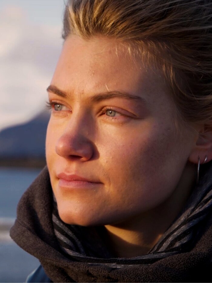 Luisa Thiel blickt ueber einen Fjord im Abendlicht
