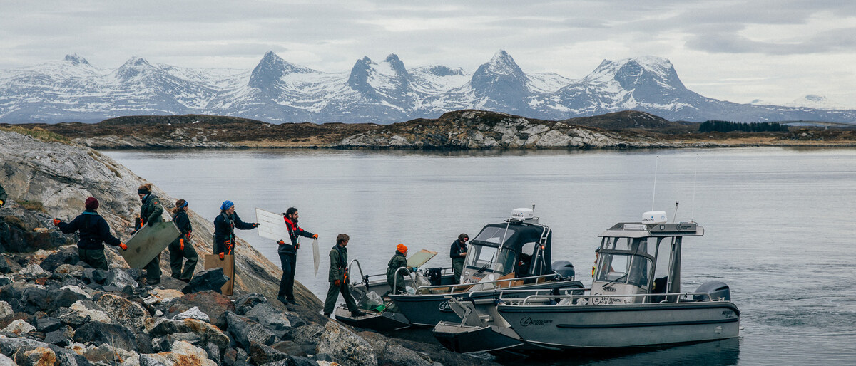 The crew loading boats below snow-covered peaks