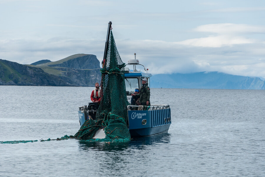 Crew pulling a ghost net out of the sea
